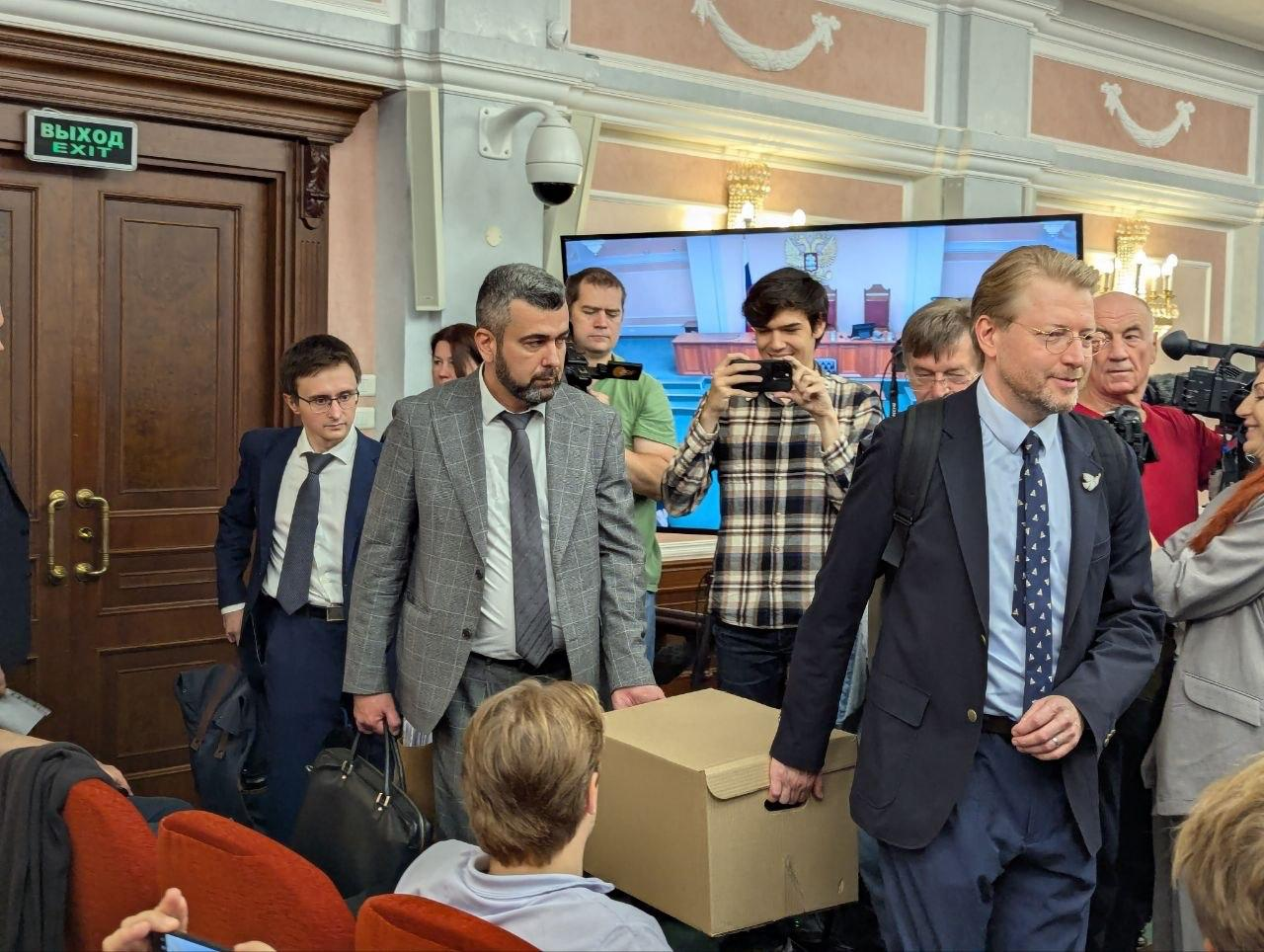 Yabloko’s chairman, Nikolai Rybakov, and the party’s defence lawyers, Gadzhi Aliyev and Vitaly Isakov, brought a box of evidence to court. Photo: Yabloko press office