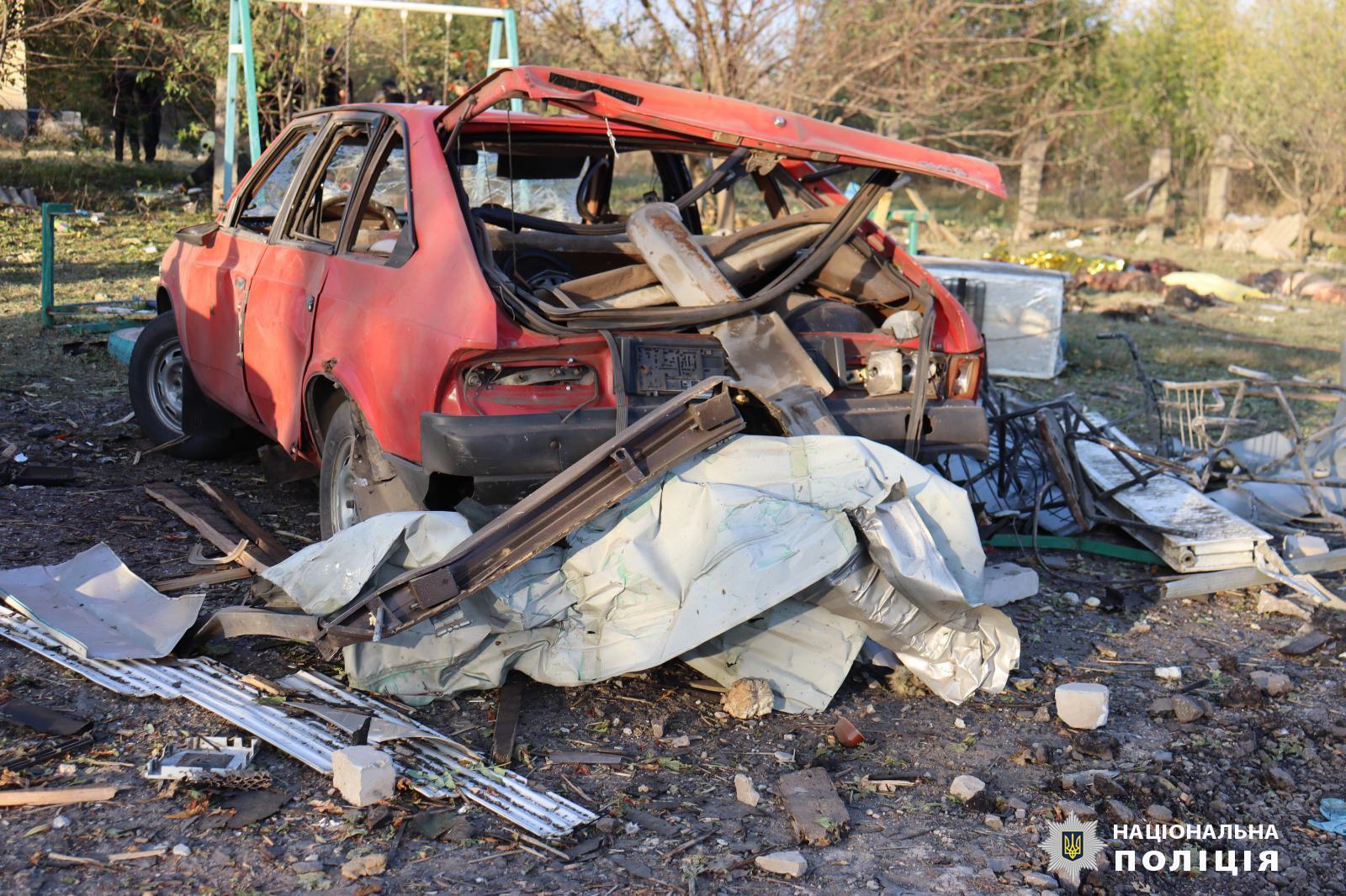 A wrecked red car among rubble and torn structural parts after a missile explosion in the village of Hroza.