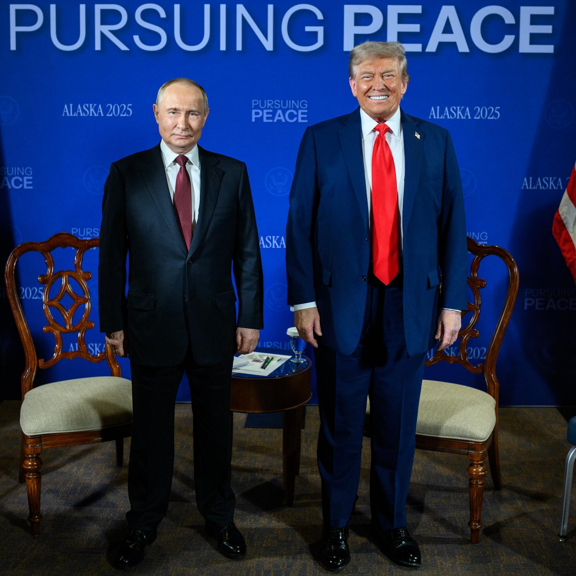 Donald Trump and Vladimir Putin standing side by side against a blue wall, Alaska, 2025